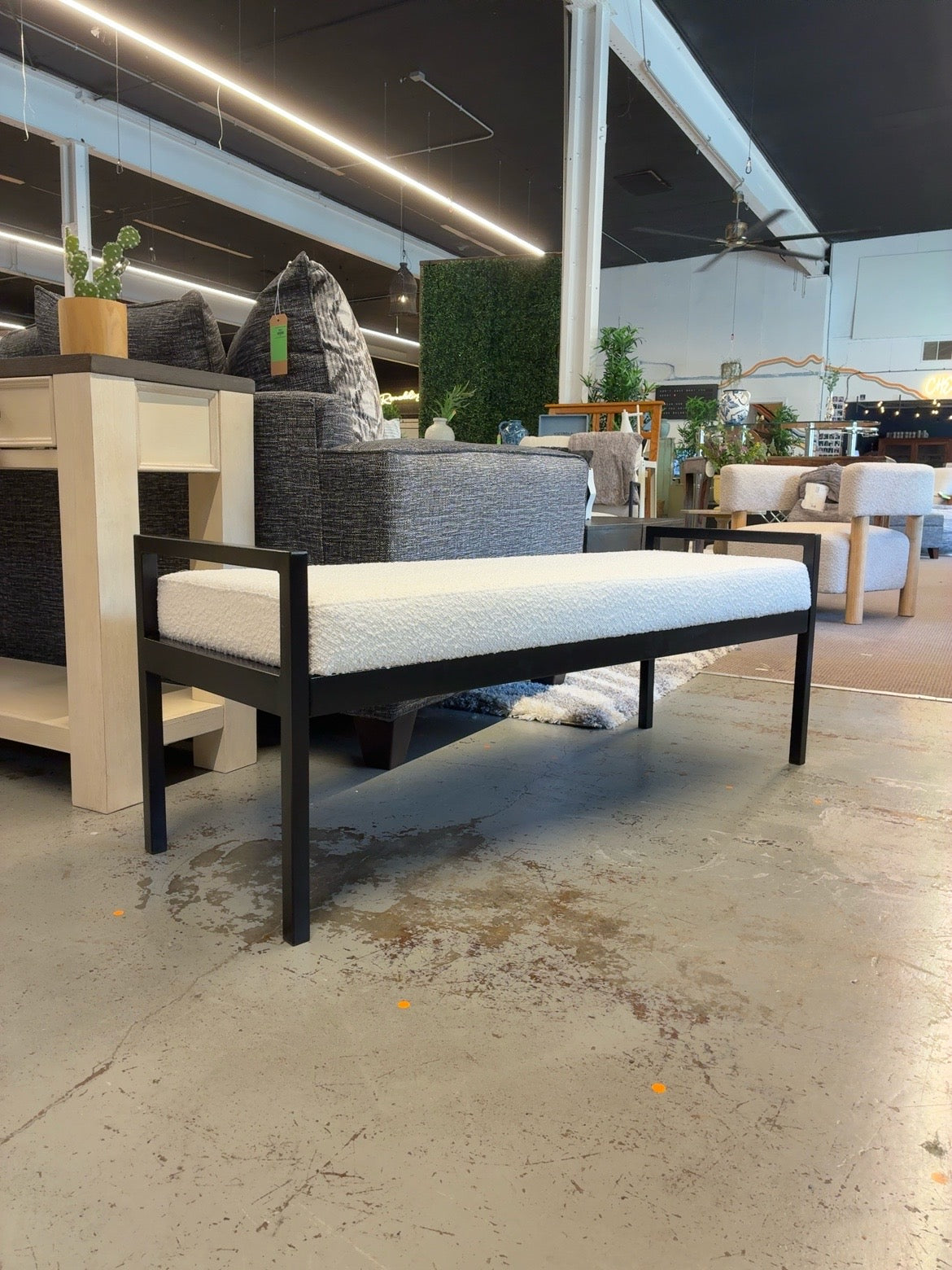 Cream textured upholstered bench with black metal frame