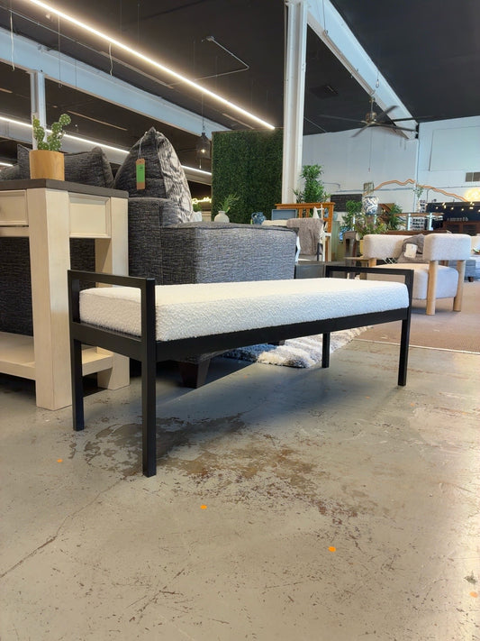 Cream textured upholstered bench with black metal frame