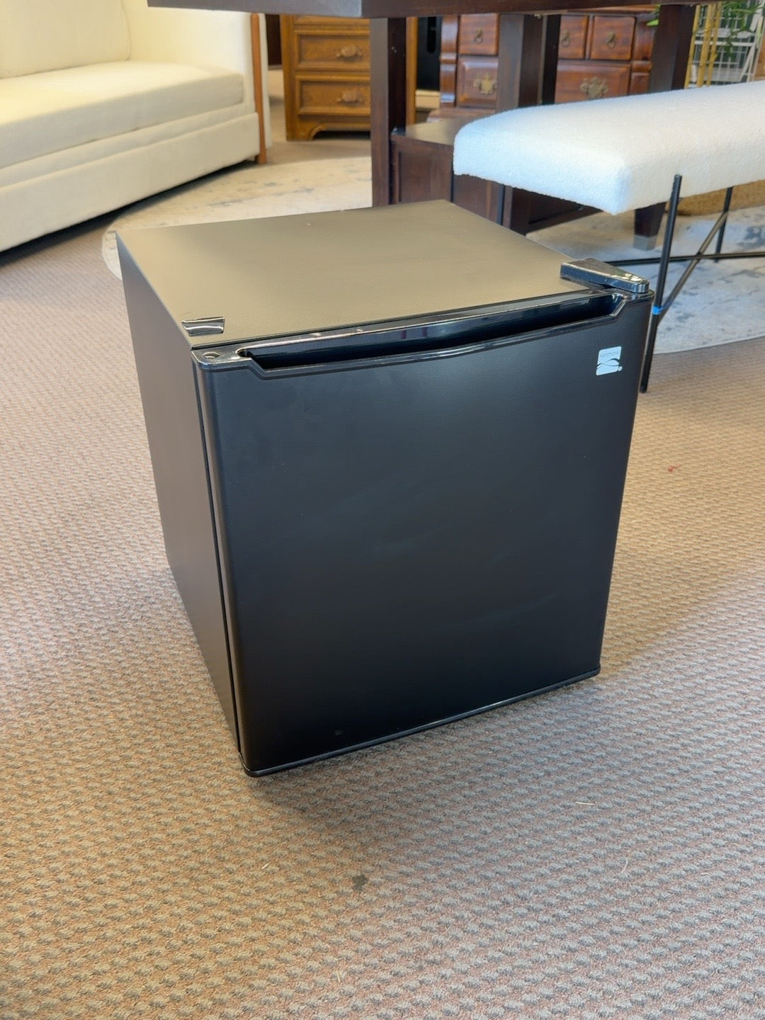 Black Kenmore mini refrigerator with visible cosmetic wear