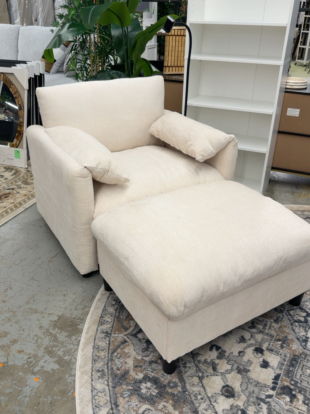 Beige upholstered ModernLuxe lounge chair with pillow armrests, flexible phone holder, and matching ottoman photographed in the Ready For Good furniture store