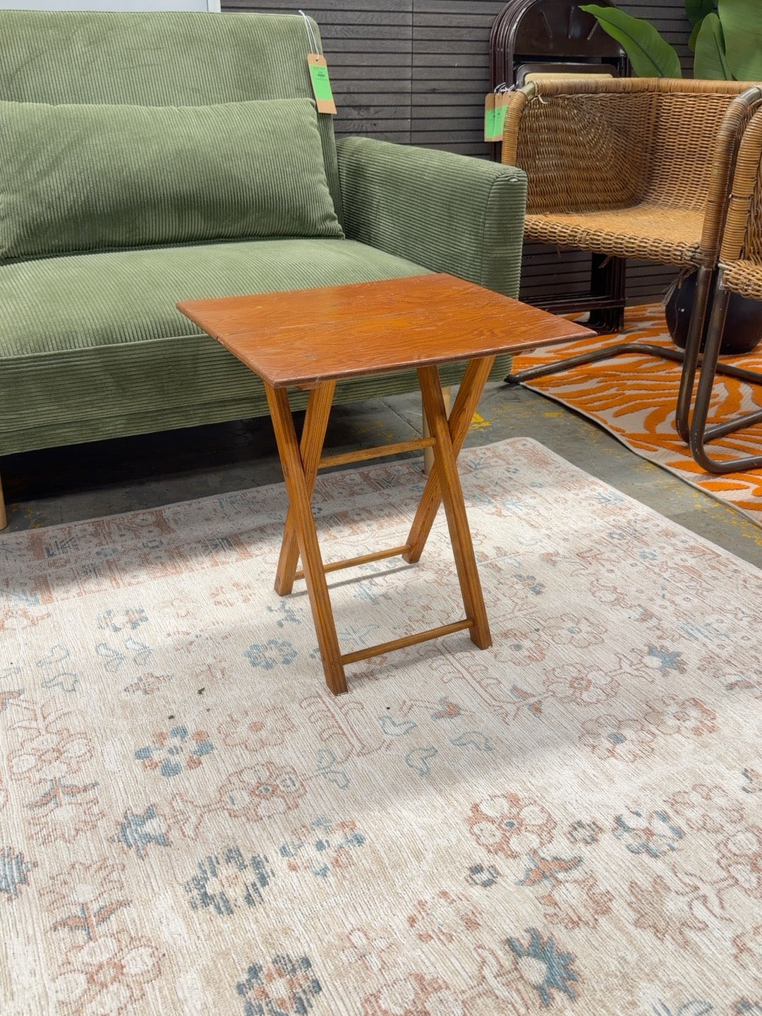 Honey brown wooden folding TV tray table with visible tabletop finish wear