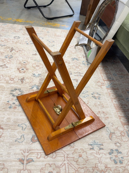 Underside of wooden folding TV tray showing folding latch and frame